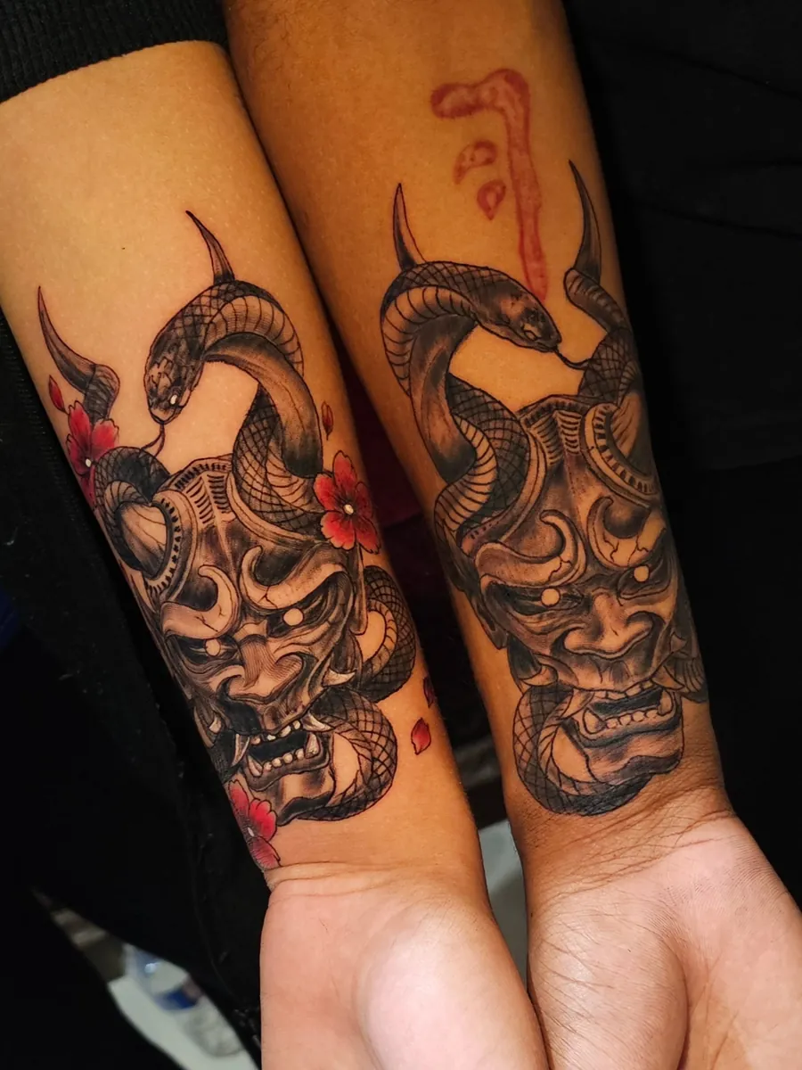 Tatuagens de casal com máscaras orientais e detalhes em vermelho