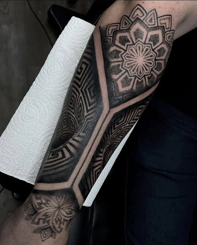 Tatuagem geométrica com mandala no antebraço