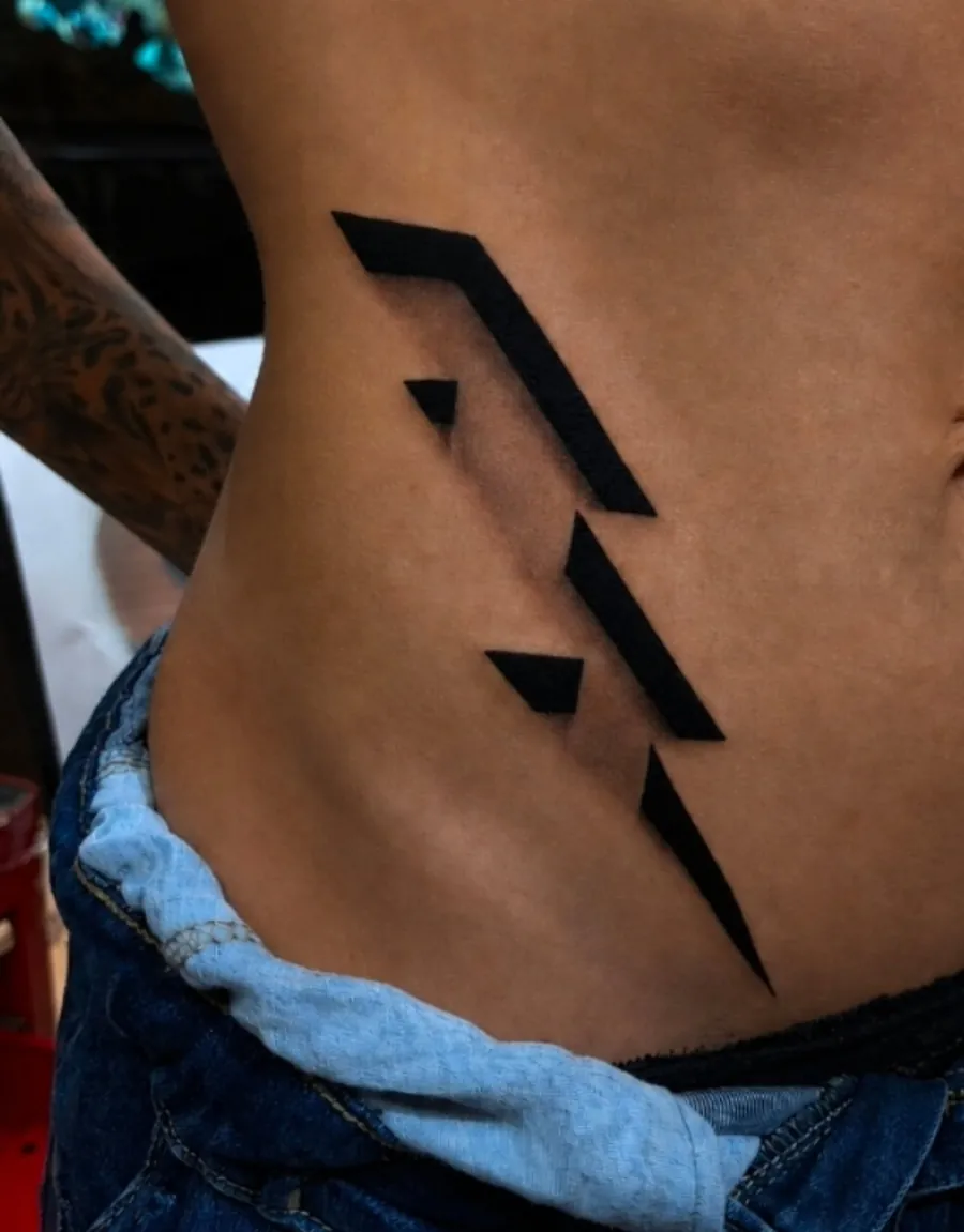 Tatuagem em preto sólido com efeito de baixo-relevo 3D na costela