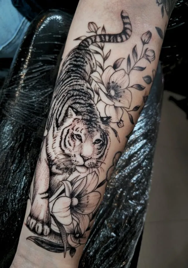 Tigre com flores em preto e cinza no antebraço